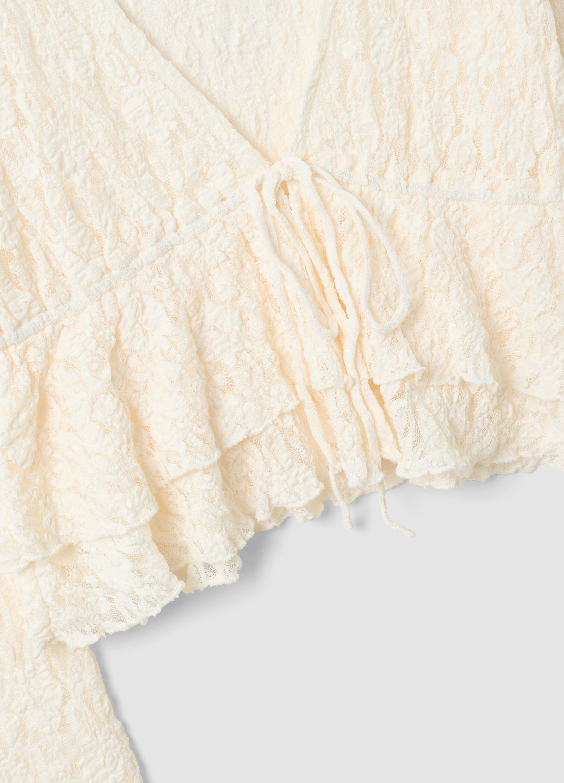 White stretch top with deep V-neck and ruffle trim