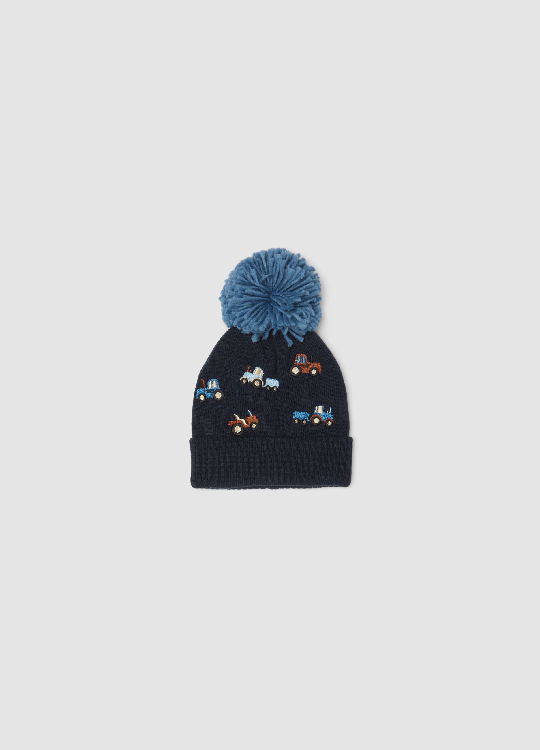 Blue knitted hat with pompom and tractor embroidery