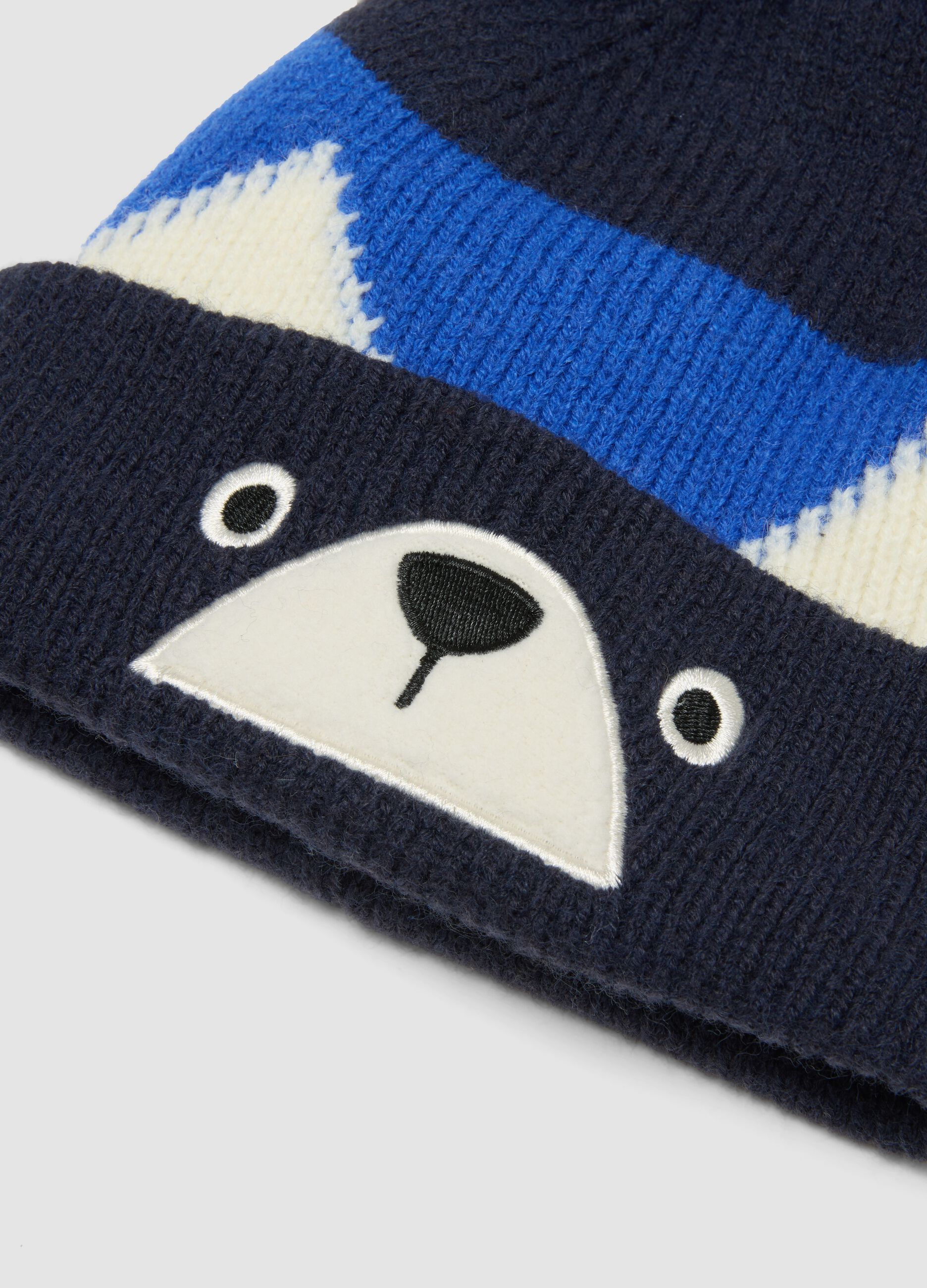 Blue knitted hat with pom-pom and animal motif