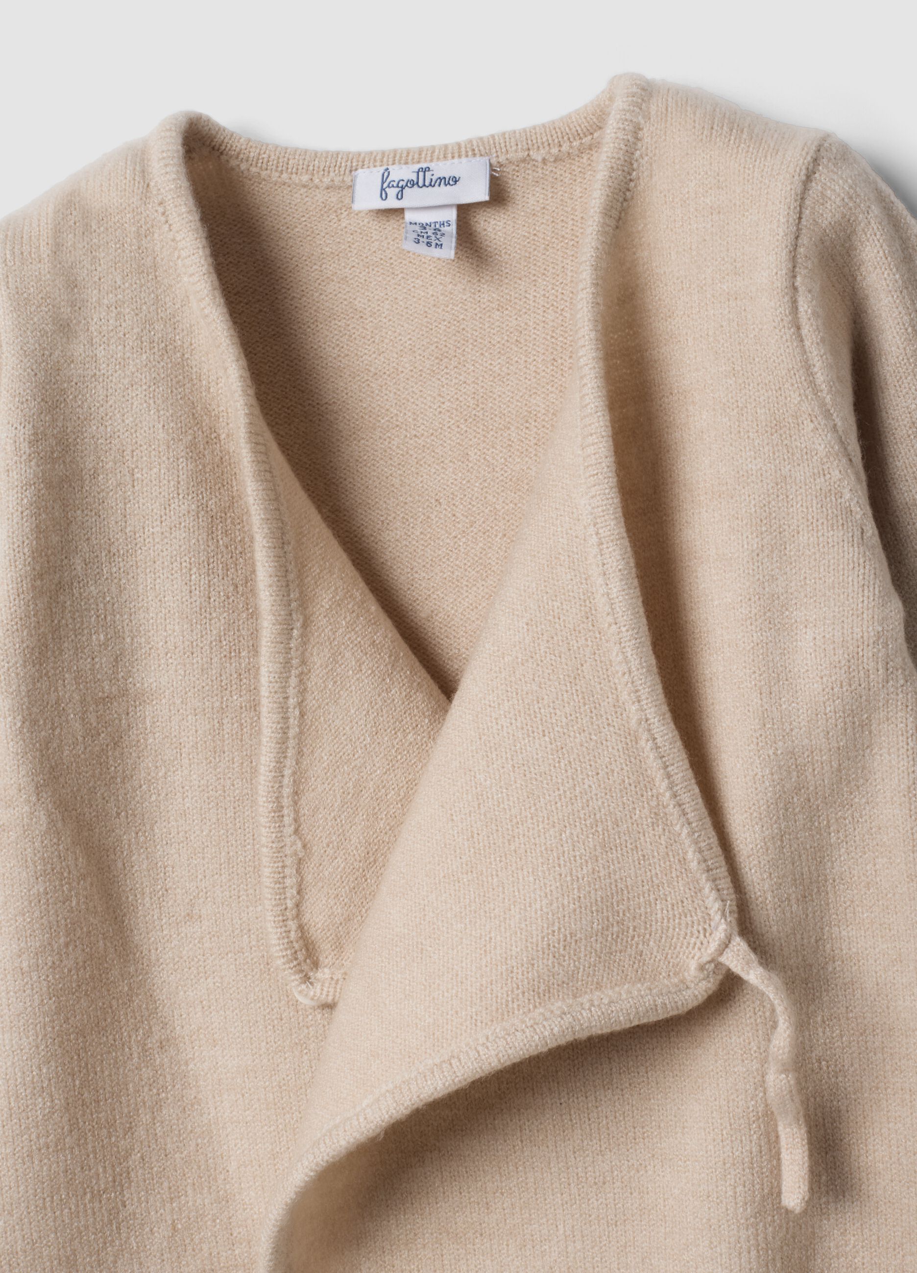 Beige baby sleepsuit with feet and wrap closure