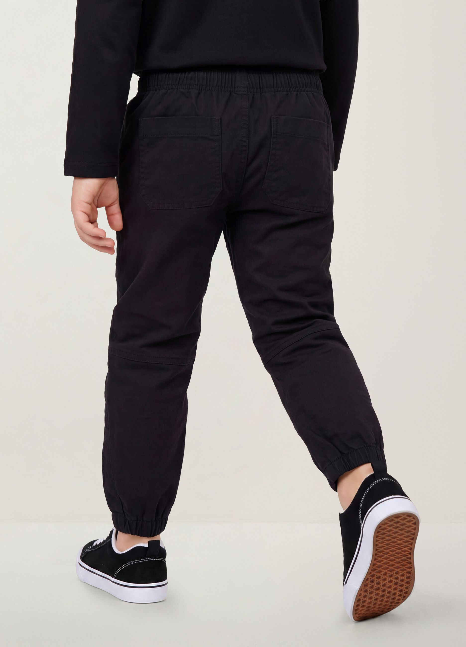 Pantaloni neri in cotone elasticizzato con fondo elasticizzato per bambino